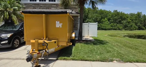Champs dumpster trailer parked on a short Lake Mary driveway beside the homeowner's SUV