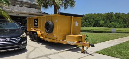 Side view of the Champs dumpster set along the driveway with the garage still open and reachable
