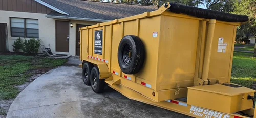Close view of the Champs dumpster parked on the Winter Springs driveway near the front door