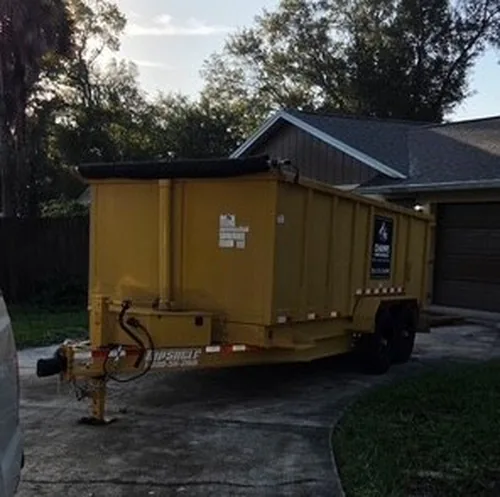 The Champs dumpster at rest on the Winter Springs driveway with walking room on both sides