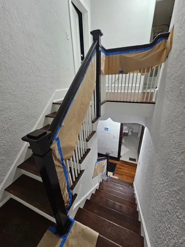 Wide view of the upper Winter Park staircase staged for restaining