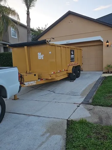 Trimmed palms beside a Champs dumpster at a Bay Hill home in Orlando